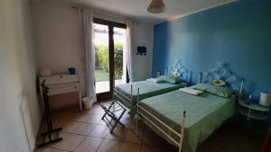 a blue room with two beds and a window at La Casa Azzurra in Misano Adriatico