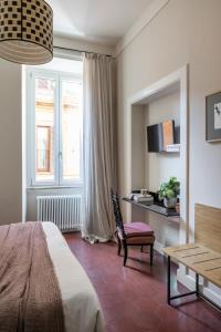een slaapkamer met een bed, een bureau en een raam bij MyNavona in Rome +54 foto's