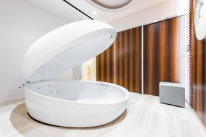 a white bathroom with a large white bath tub at Adams Beach Hotel & Spa in Ayia Napa