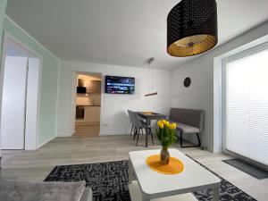 ein Wohnzimmer mit einer Vase mit Blumen auf einem Tisch in der Unterkunft Henning 1 in Kirchdorf