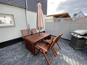 un patio con 2 sillas, una mesa y una sombrilla en Henning 1 en Kirchdorf