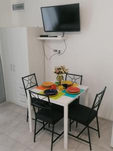 a dining room table with chairs and a tv on the wall at Gladiator Noclegi Zator II in Zator
