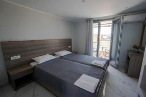 a bedroom with a large bed and a large window at Golden Dolphin Studios & Apartments in Alykes