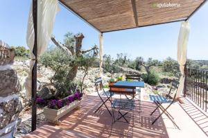 a patio with a table and chairs on a deck at I Trulli di Emma by Apulia Home in Alliste