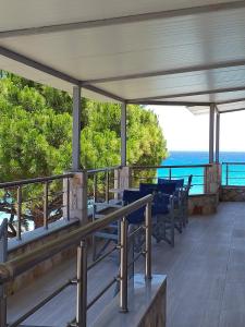 a balcony with chairs and a view of the ocean at Golden Dolphin Studios & Apartments in Alykes