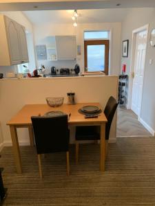 a kitchen and dining room with a wooden table and chairs at Church view in Wick