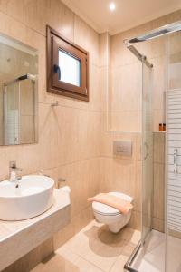 a bathroom with a sink and a toilet and a shower at Villa Pipini Luxury Studios in Limenas +32 photos