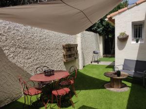 a patio with a table and chairs and an umbrella at La maisonnette de Saint Chamas in Saint-Chamas