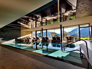 einen Pool in einem Haus mit Fenstern in der Unterkunft Lifestyle Hotel Alpin in Schenna