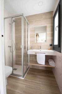 a bathroom with a sink and a glass shower at Adosado-Duplex Marea Baja 2 zona de playa y montañ in Llanes