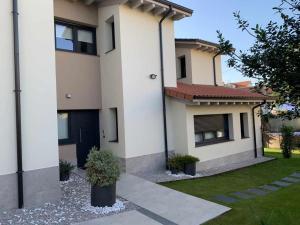 a white house with a black door and a yard at Adosado-Duplex Marea Baja 3 zona de playa y montañ in Llanes +24 photos
