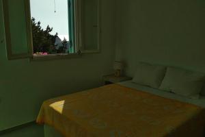 a bedroom with a bed with a window and a table at Sarakiniko in Agiassos