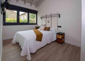 a bedroom with a large white bed and a window at adosadoduplex adaptado en zona de playa ideal familias in Llanes