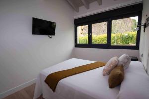 リャネスにあるADOSADO-DUPLEX ADAPTADO zona de playa y montañaの窓のある白いベッドのある寝室 +27枚の写真