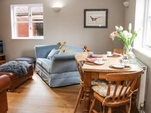 a living room with a table and a couch at Blossom's Cottage in Shrewsbury