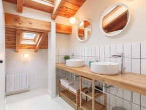 two sinks in a bathroom with wooden ceilings at Tranquilidad en la Reserva de Urdaibai in Canala
