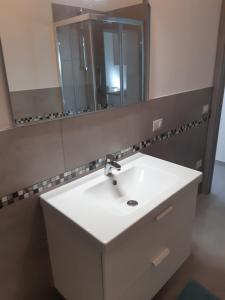 bagno con lavandino bianco e specchio di Villa Lina a Rimini