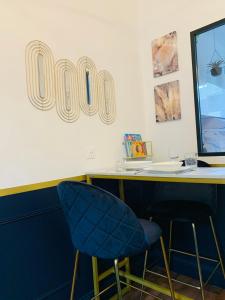 eine Bar mit einem blauen Stuhl und einem Schreibtisch mit einem uo-Schild in der Unterkunft Homard & Fox, Le Féart, Studio avec coin terrasse & barbecue in Dinard