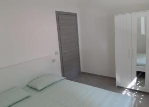 a white bedroom with a bed and a closet at Villa Lina in Rimini