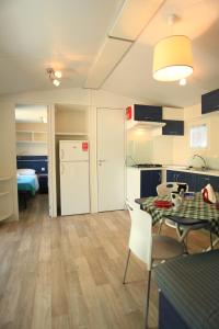 a kitchen and living room with a table and chairs at Camping Bella Italia in Peschiera del Garda