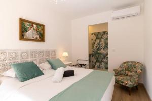 ein Schlafzimmer mit einem großen weißen Bett und einem Stuhl in der Unterkunft Bien d'exception en face du Palais des Papes in Avignon