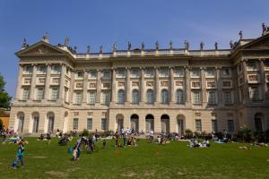 a large building with people on the grass in front of it at L'Ottava GuestHouse in Milan