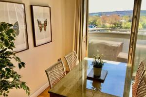 a dining room with a table and chairs and a window at Stylish Quayside 2 bed apartment with beautiful river views in Newcastle upon Tyne