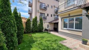 a garden in front of a building with a lawn at Vila Albertino in Eforie Nord