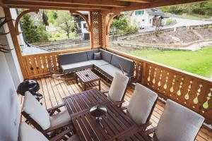 einen Balkon mit einem Sofa, Stühlen und einem Tisch in der Unterkunft Ferienwohnungen Villa Salzweg in Bad Goisern
