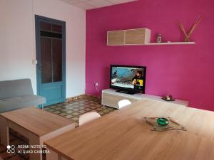 a living room with a table and a pink wall at Apartamento vinamar in Vinarós