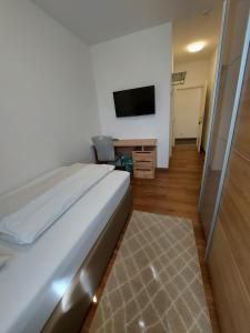 a bedroom with a bed and a desk and a television at Wollsdorferhof in Sankt Ruprecht an der Raab