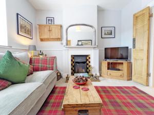 a living room with a couch and a fireplace at Sparrow Cottage - Westbourne in Westbourne