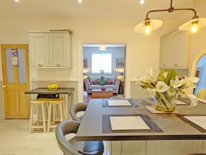 a kitchen and living room with a table and chairs at Sparrow Cottage - Westbourne in Westbourne
