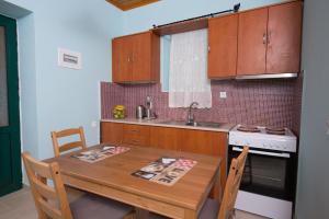 a kitchen with a wooden table and a sink and a stove at Πέτρινο σπίτι in Lazaráta