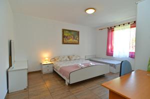 een slaapkamer met een bed, een tafel en een bureau bij Apartment Branko 2081 in Pula
