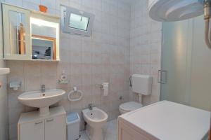 une salle de bain blanche avec un lavabo et des toilettes dans l'établissement Apartment Branko 2081, à Pula 13 autres photos