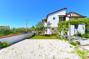 une maison blanche avec un mur blanc et des arbres dans l'établissement Apartment Branko 2081, à Pula