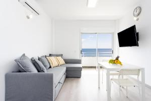 San Andrés的住宿－Home2Book Sea Front Las Teresitas Beach 4，客厅配有灰色的沙发和桌子