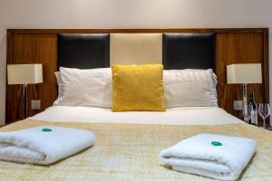 a bedroom with a bed with two towels on it at Victoria Court Suites - Aberdeen in Aberdeen