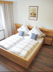 a bed with four pillows on it in a room at Ferienwohnungen Irmengard in Bernau am Chiemsee