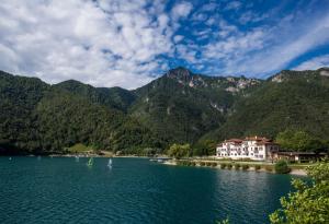 a body of water with mountains in the background at Hotel Lido in Ledro