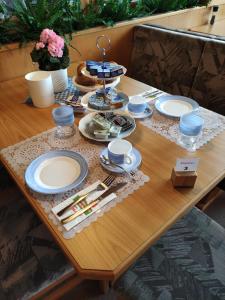 uma mesa de madeira com pratos e pratos em Pension zum Mühlrad em Millstatt