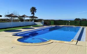 a swimming pool in a yard with a fence at Apartamentos na Quinta Altavista do Carvalhal in Zambujeira do Mar