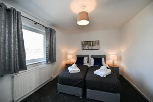 a bedroom with a bed with two pillows on it at Mews House in Ayr