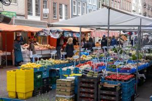 a group of people walking around a market with fruits and vegetables at Guesthouseamsterdam in Amsterdam