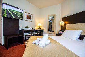 een hotelkamer met een bed en een flatscreen-tv bij Tuscany Inn in Montecatini Terme
