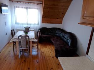 a living room with a table and a leather couch at Apartmani Bane in Kremna