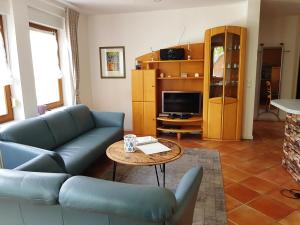 ein Wohnzimmer mit einer Couch und einem Tisch in der Unterkunft Ferienwohnung Mönchgut 1 mit Wintergarten und Terrasse in Ostseebad Sellin
