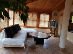 シュピーゲラウにあるFerienhaus Klingenbrunnのリビングルーム(白いソファ、コーヒーテーブル付)