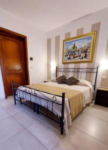 ポルト・チェザーレオにあるChalet del Mareのベッドルーム1室(壁に絵画が描かれたベッド1台付)